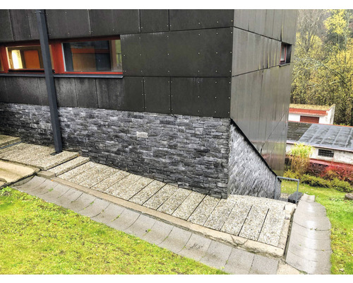 Venkovní pohled na budovu s obkladem fasády s kamenným vzhledem a moderními panely.