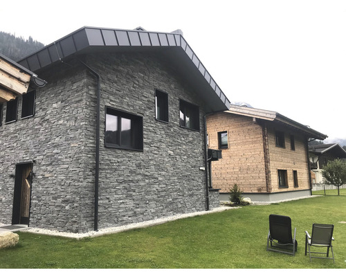 Fasáda domu s obkladem z přírodního kamene a dřevěnými detaily