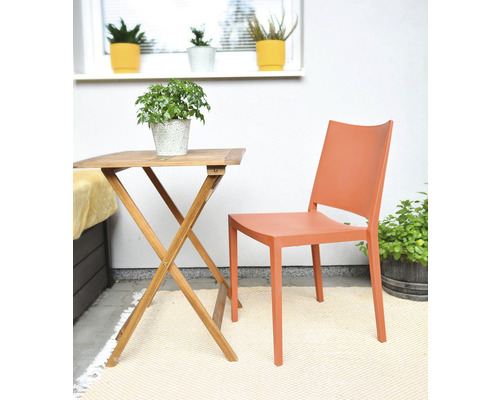 Zahradní scéna s dřevěným stolem, plastovou židlí a pokojovými rostlinami