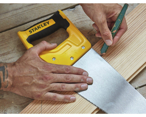 Ruční pila s kusem dřeva a tužkou v ruce.