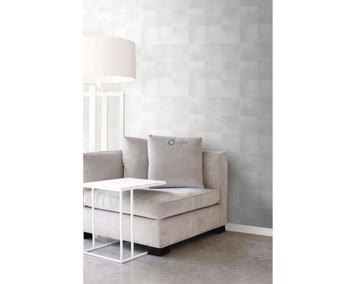 Obývací pokoj s šedou vzorovanou tapetou, pohovkou, stolem a lampou