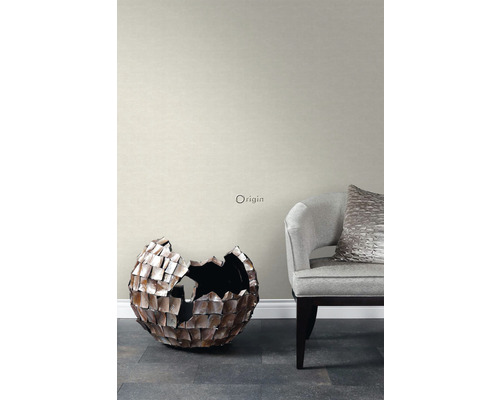 Obývací pokoj s šedou tapetou, dekorativní koulí a křeslem.