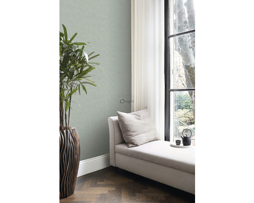 Obývací pokoj se zelenou tapetou, lehátko, pokojová rostlina a okno