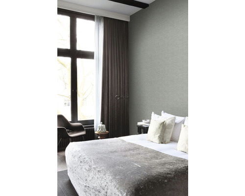 Ložnice s postelí, nočním stolkem a oknem se závěsy a šedou textilní tapetou