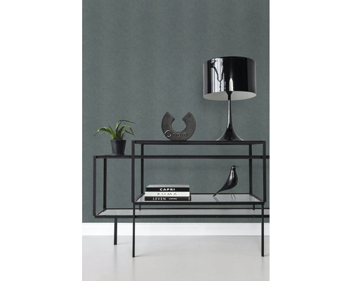 Ozdobné předměty na polici před vzorovanou tapetou.