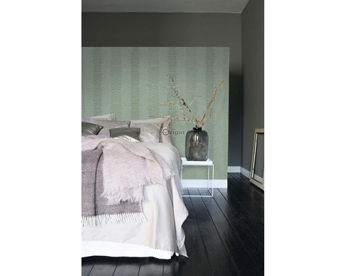 Moderní ložnice s vzorovanou tapetou, postelí, příručním stolkem a dekorací