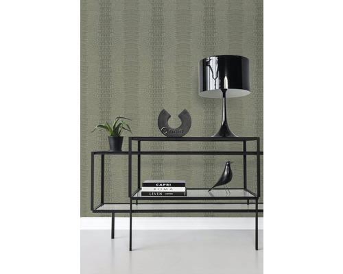 Ozdobná police se stolní lampou, pokojovou rostlinou a tapetou se vzorem plazů v pozadí