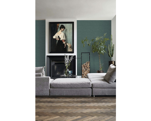 Obývací pokoj s šedou pohovkou, krbem, obrazem a dřevěnou podlahou.