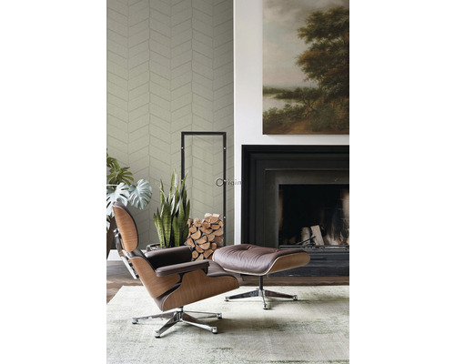 Obývací pokoj s křeslem, podnožkou, krbem a vzorovanou tapetou