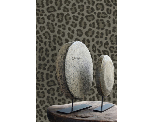 Dva dřevěné dekorační předměty na stole s tapetou se zvířecím vzorem v pozadí