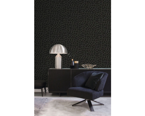 Obývací pokoj s černou tapetou se zvířecím vzorem, křeslem a komodou