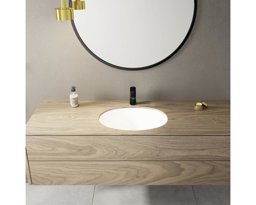 Moderní koupelna s umyvadlovou skříňkou, umyvadlem na desku a kulatým zrcadlem