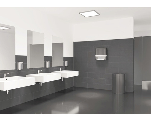 Světlá koupelna se třemi umyvadly, zrcadly, dávkovači mýdla, zásobníkem papírových ručníků a odpadkovým košem