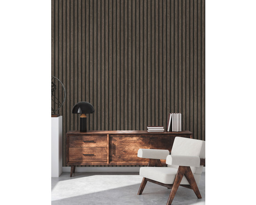 Interiér s obkladem stěn z dřevěných panelů, příborníkem, lampou, knihami a křeslem.