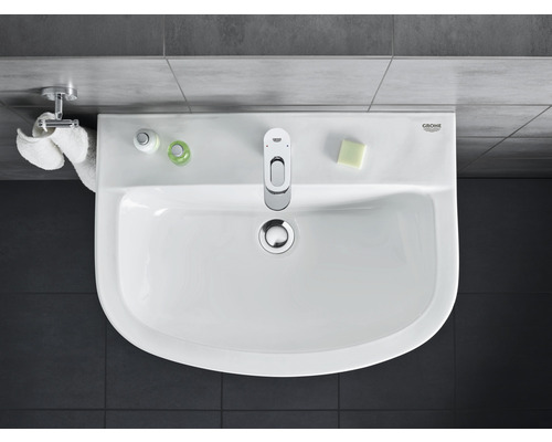 Pohled shora na umyvadlo s baterií, mýdlem a ručníky v koupelně