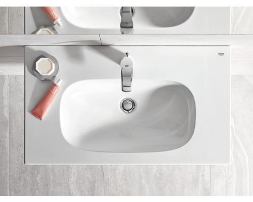 Pohled shora na bílé umyvadlo s vodovodní baterií