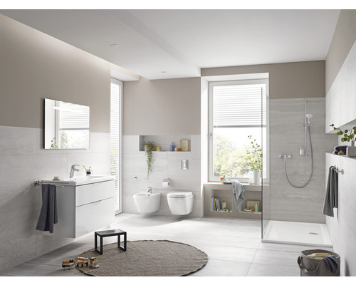 Světlá koupelna s umyvadlem, zrcadlem, bidetem, toaletou a sprchou.