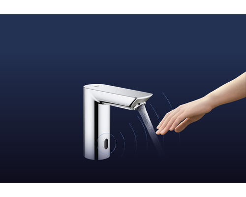 Vodovodní kohoutek se senzorem a rukou pod tekoucí vodou