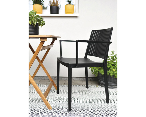 Černá zahradní židle s područkami vedle dřevěného stolu na terase