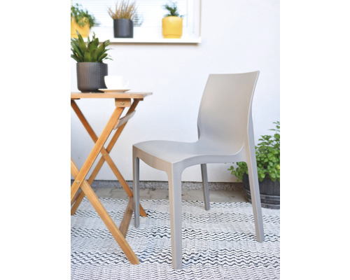 Scéna s šedou plastovou zahradní židlí a dřevěným stolem na balkóně