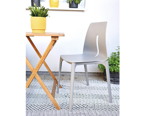 Zahradní scéna se skládacím stolem, zahradní židlí a květináči na koberci