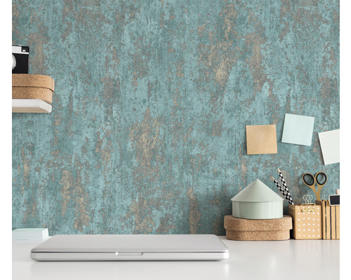 Scéna se strukturovanou tapetou, notebookem a kancelářskými potřebami na bílém stole.