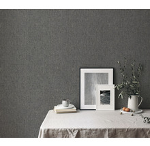 Detailní záběr strukturované šedé tapety v interiéru s dekorací stolu