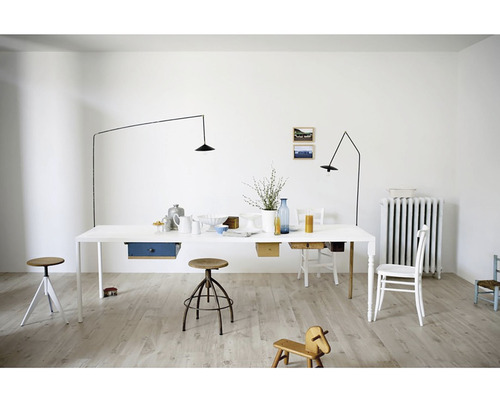 Světlá místnost s velkým jídelním stolem, minimalistickými lampami a dřevěnými podlahami