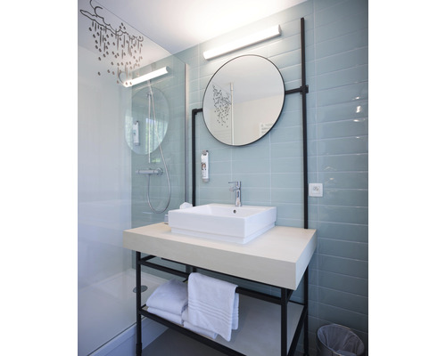 Moderní koupelna se sprchou, umyvadlem, zrcadlem a ručníky