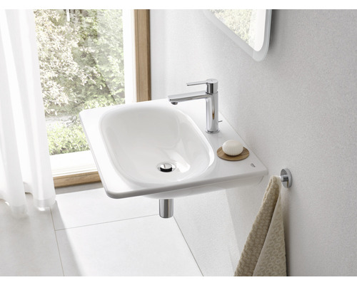 Moderní koupelna s bílým umyvadlem, vodovodní baterií a držákem na ručníky.