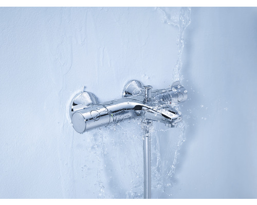 Nástěnná sprchová baterie s proudem vody na zdi