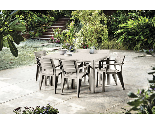 Čtvercový zahradní stůl s osmi židlemi v zelené zahradě.