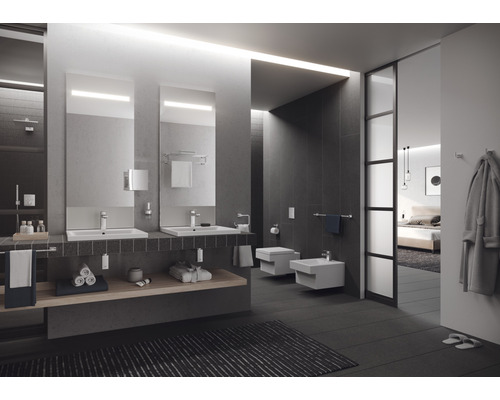 Moderní koupelna s umyvadly, zrcadly, toaletou a bidetem.