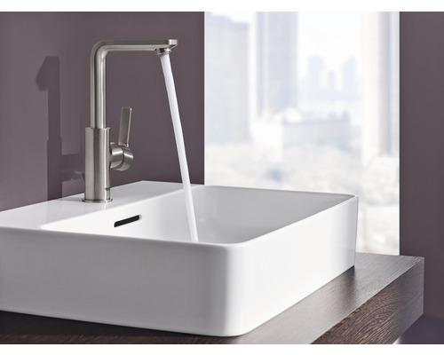 Umyvadlo s vodovodní baterií a tekoucí vodou v koupelně.