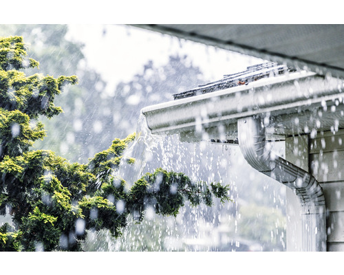 Dešťová voda teče ze střechy do okapu.