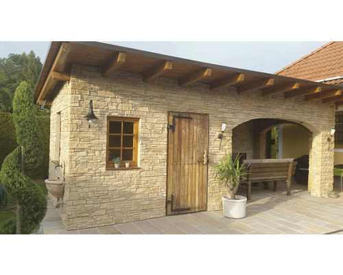 Vnější pohled na zahradní domek s kamenným obkladem, dřevěnými dveřmi a oknem