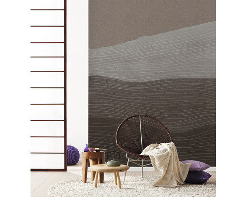 Obývací pokoj s vzorovanou tapetou, křeslem, kobercem a příručními stolky