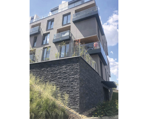 Vícepodlažní obytný dům s balkony a fasádou z přírodního kamene