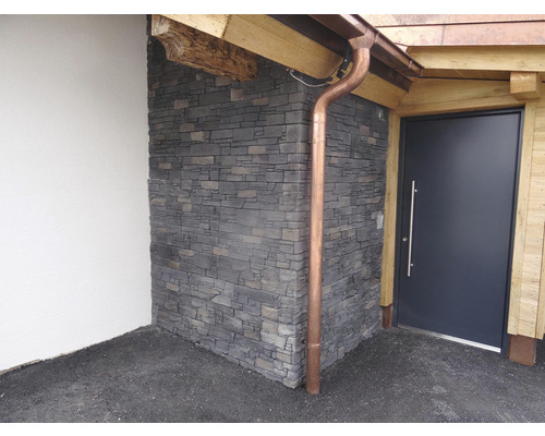 Vstupní prostor s kamennou stěnou, vchodovými dveřmi a okapem