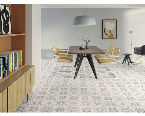 Jídelna se stolem, židlemi a vzorovanou dlažbou pro stylový vzhled.