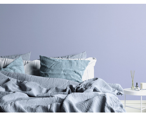 Ložnice s postelí, polštáři a odkládacím stolkem