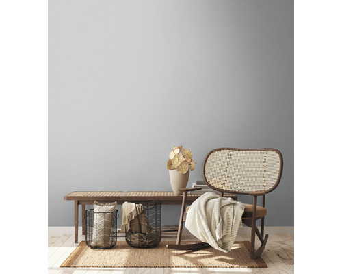 Obývací pokoj s dřevěnou lavicí, proutěným houpacím křeslem a dekoracemi