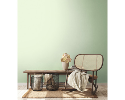 Světlý, přátelský interiér s lavicí, ratanovým křeslem, košíky a dekorací na koberci.