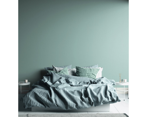 Ložnice s postelí, polštáři a nočními stolky.