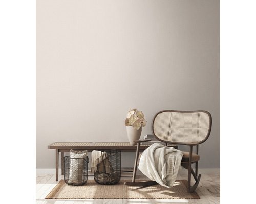 Obývací pokoj s lavicí, proutěným houpacím křeslem, koši a dekorací na koberci.