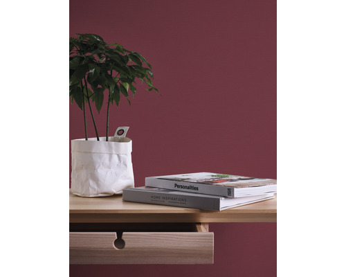 Dekorativní aranžmá s pokojovou rostlinou v papírovém obalu, knihami a dřevěným psacím stolem