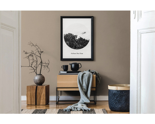 Dekorativní pokoj s komodou, zarámovaným obrazem, košem a dřevěnou stoličkou.