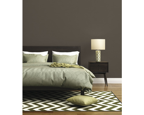 Ložnice s postelí, noční lampou a kobercem se vzorem cikcak