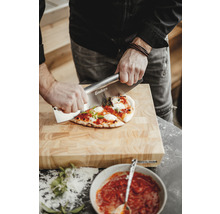 Osoba krájí pizzu na dřevěném prkénku pomocí kráječe na pizzu značky Enders.