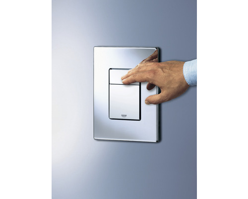 Ovládací tlačítko Grohe s rukou namontovanou na zdi